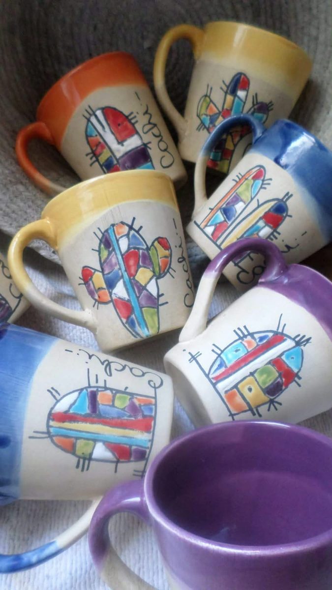 Tazas de cerámica con bordes de colores y cactus pintados en mosaico, con la palabra Cachi escrita a mano